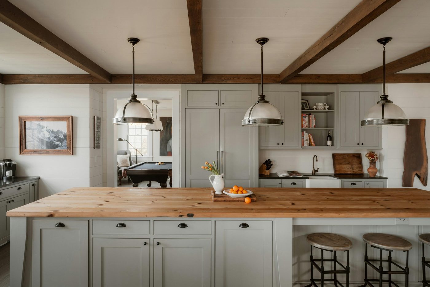A warm farmhouse kitchen with an oak island and beamed ceiling
