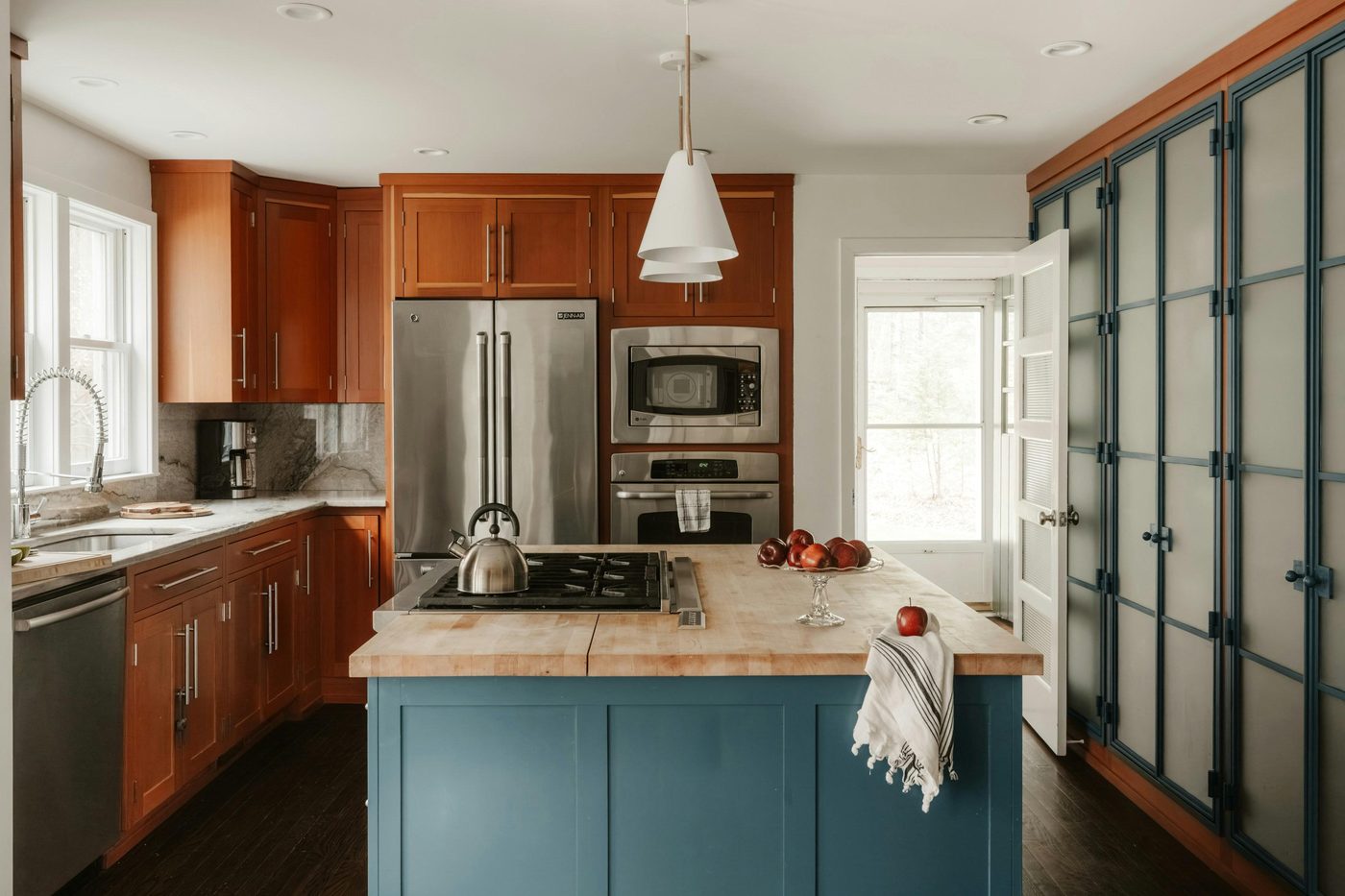A cheerful teal kitchen island, tidy and ready for the day