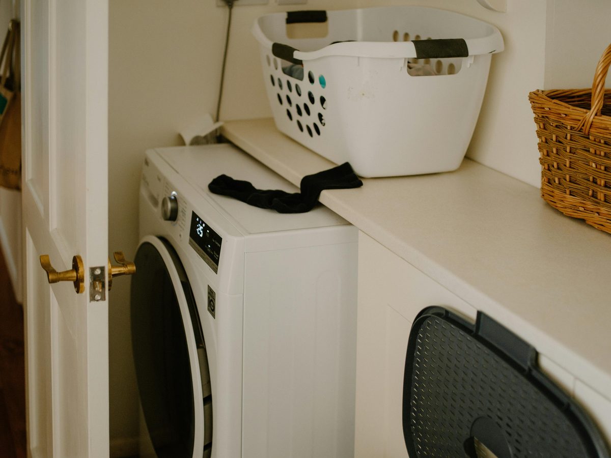 A tidy laundry closet, basket ready to go